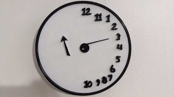 A black-and-white clock face is shown. The numerals are ranged around the right edge of the clock. One pointer extends from the center of the clock, and one is on the left side of the face.